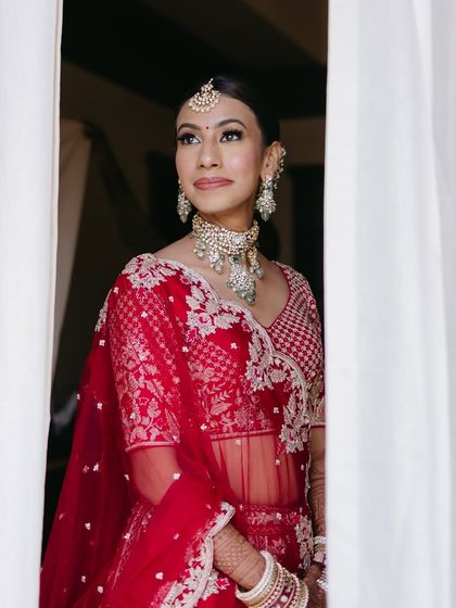 A candid moment of the bride looking out the window, looking thoughtful and beautiful. Her makeup is designed to look stunning from every angle.