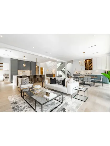 We specialize in creating open, airy living spaces where the kitchen and living room flow together seamlessly. This design features a modern aesthetic with clean lines, a balanced color palette, and distinct zones for cooking, dining, and relaxing, demonstrating our expertise in holistic home interior planning.