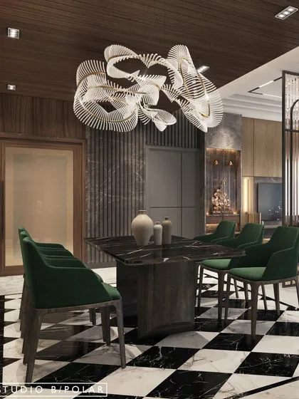 The dining area is anchored by a dramatic black and white checkered marble floor and a sculptural chandelier. The rich green chairs add a pop of color, creating a sophisticated space for formal dining.