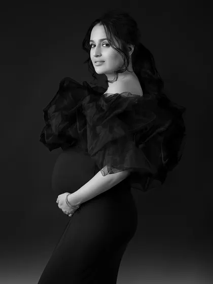 A close-up portrait in black and white, capturing her confident expression and the details of her pose.
