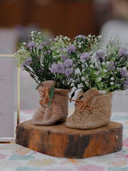 A creative detail shot from a baby shower, with flowers arranged in tiny knitted booties.