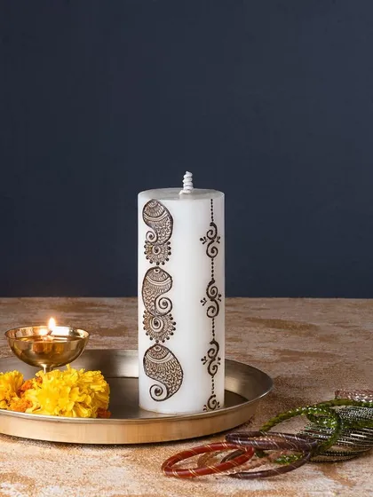 This pillar candle features an intricate paisley mehendi design. It's a beautiful and elegant piece that works wonderfully for weddings, festivals, or just as home decor.