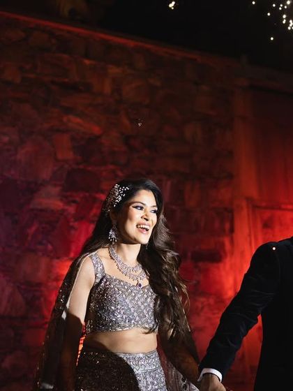 A dramatic entrance for a cocktail event in Udaipur. The bride's sparkling gown is paired with a glamorous makeup look, perfect for a night of celebration.