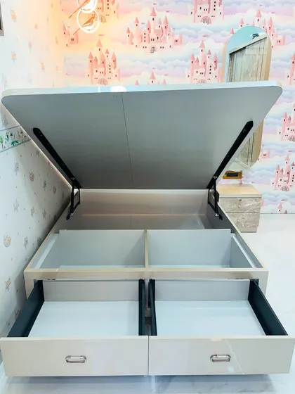 A demonstration of the dual storage options in this custom bed: both hydraulic lift storage and pull-out drawers.