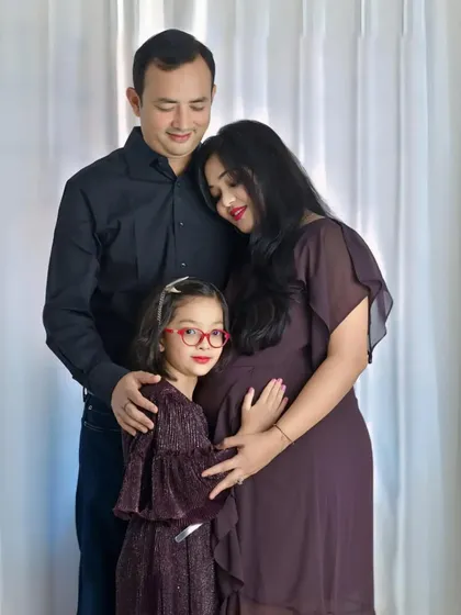 A complete family portrait celebrating the upcoming arrival. The parents and big sister-to-be gather close, creating a warm and loving image that documents this precious moment in their family's story.