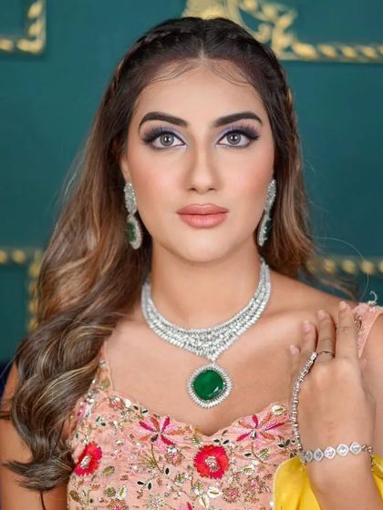 A beautiful close-up of the model, focusing on the stunning emerald and diamond necklace that elevates this floral rental look.