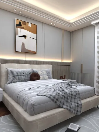 This bedroom combines soft grey upholstery with warm wood flooring and modern art. The layered bedding and ambient lighting create a cozy and sophisticated retreat.
