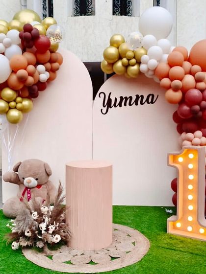 A warm and modern boho theme for baby Yumna's first birthday. We used an earthy palette of brown, beige, and terracotta balloons, a teddy bear prop, and a light-up number '1' for a chic and cozy celebration.