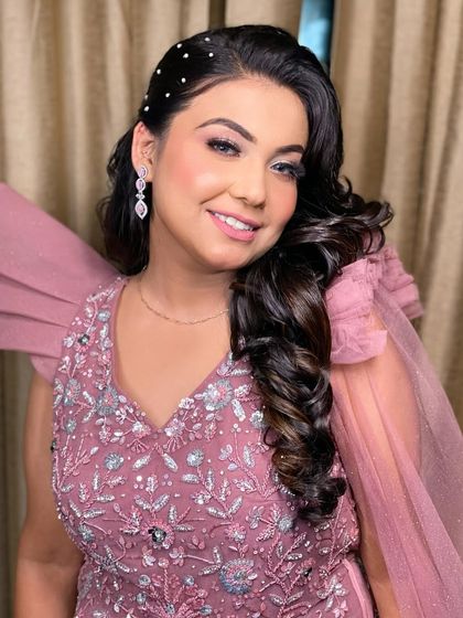 A smiling portrait of the same client, looking radiant and happy in her dusty pink gown.