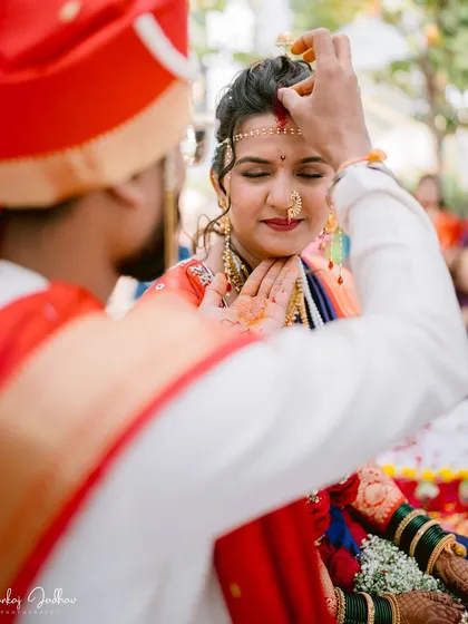 A sacred moment as the groom applies sindoor to the bride's forehead, a key ritual in a Hindu wedding ceremony, captured with intimacy and respect.