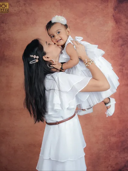 A mother's love captured in a sweet kiss on her daughter's cheek.