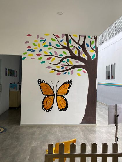 A simple but impactful butterfly mural we painted at a preschool. This large, colorful butterfly next to a tree serves as a perfect photo point for the kids.