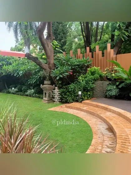 Curved brick steps lead from a deck down to the lawn. We use natural materials and organic shapes to create a gentle and harmonious transition between different levels in the garden.