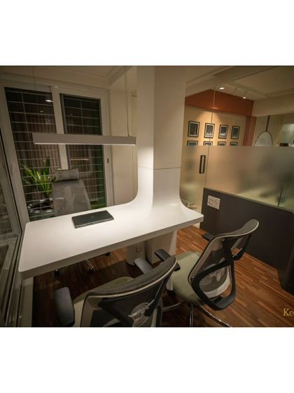 The principal architect's desk, designed with clean lines and a minimalist aesthetic. It overlooks a small green space, bringing a touch of nature into the workspace.