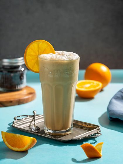 An orange-flavored coffee shake, garnished with a slice of orange for a zesty look.