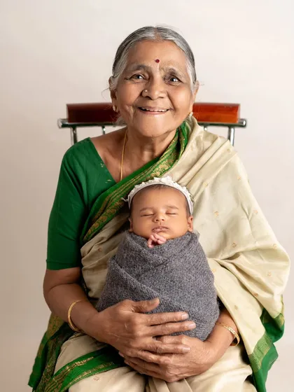 A great-grandmother holds her great-grandchild, a beautiful portrait of four generations of love.
