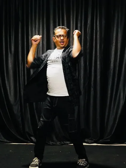 Pure joy and energy on stage! A performer dances with enthusiasm during our open mic night, showing that our stage is for anyone who wants to express themselves freely.