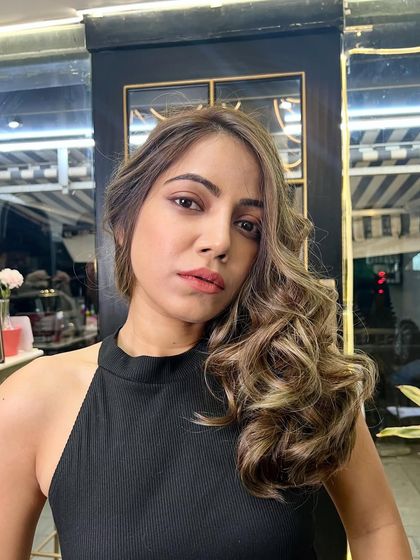 A selfie of the client loving her new ash blonde balayage. The side-swept style shows off the beautiful curls and the dimension of the color.
