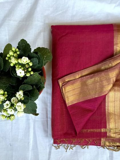 A rich magenta Maheshwari silk cotton saree with a simple gold zari border. This is a classic, festive piece.