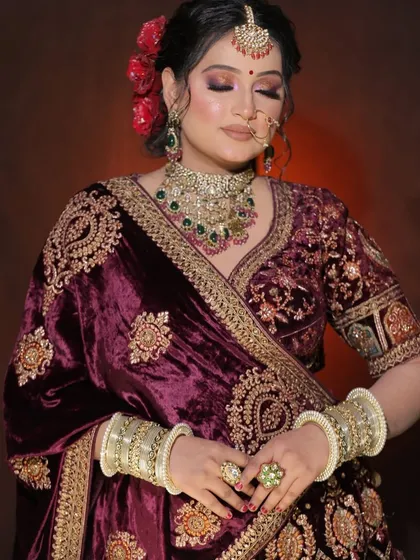 A bride styled in our heavily embroidered wine-colored velvet lehenga. These portraits are a perfect example of a classic bridal look for any MUA's book.