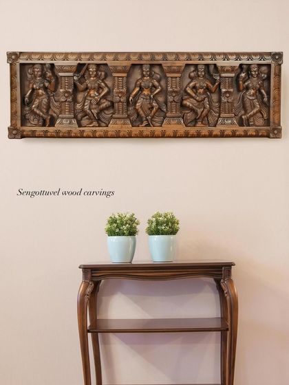 A 36-inch horizontal panel depicting five celestial Apsaras in various dance poses. The natural wood finish highlights the fluid carving and makes it a sophisticated piece of wall art.