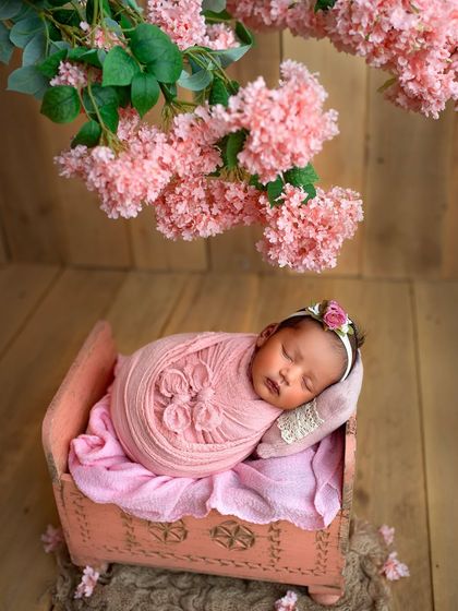 Another angle of the pink cot setup, showing the beautiful details of the wrap and the hanging flowers above.