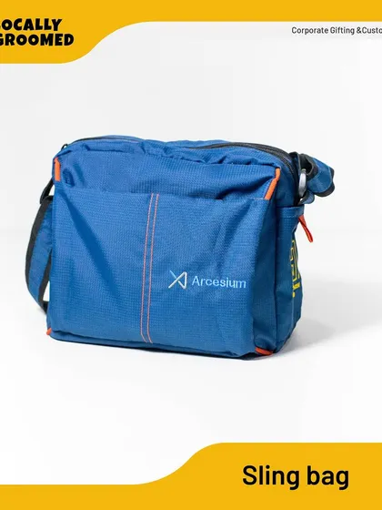 A versatile blue sling bag with orange accents, customized for Arcesium. It's a great hands-free option for carrying daily essentials.
