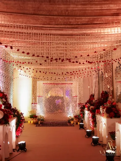 The pathway to a celebration should build anticipation. I lined this entrance with lush red rose arrangements and created a ceiling of hanging white florals to set a magical, elegant tone from the very first step.
