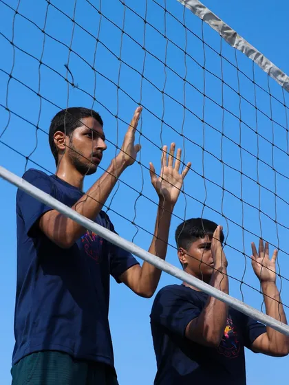 Two players practice their blocking form at the net. We teach our players to form a solid wall, an essential part of a strong team defense.