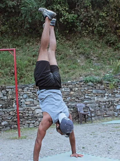 Practicing handstands outdoors. Bodyweight training can be done anywhere, connecting your fitness routine with nature.