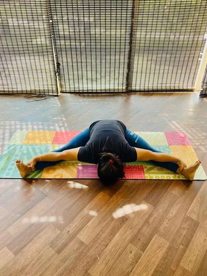 A deep forward fold in Upavistha Konasana. This pose is excellent for opening the hips and stretching the hamstrings. My student shows great depth here, a result of her consistent efforts.