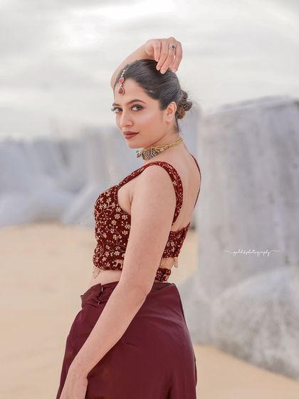 A beachside fashion shoot for a designer's modern-ethnic collection. The models are posed against the sea and coastal rocks to create a windswept, editorial feel that highlights the clothing.