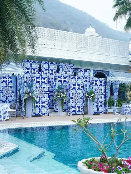 For a chic and modern Mehendi, we transformed this poolside at The Leela Palace in Jaipur into a Mediterranean dream. The decor, inspired by blue pottery, created a stunning contrast against the water, offering a refreshing and elegant atmosphere for a daytime celebration.