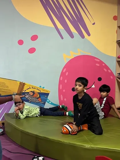Finding a comfy spot to listen to a story. Our relaxed environment allows kids to be themselves, whether they're sitting, lying down, or acting out the characters.