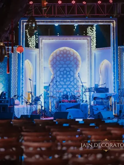 A sangeet stage that is both luminous and artistic. The backdrop features intricate geometric patterns inspired by Turkish design, lit from within to create a mesmerizing effect for the musical night.
