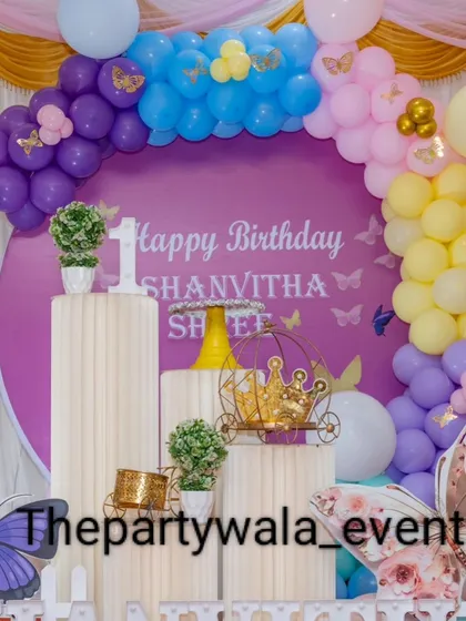 A close-up of the main backdrop and props for the purple butterfly theme. The small details like the golden butterflies on the balloons add extra sparkle.