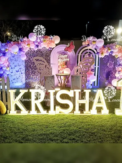 A nighttime view of the butterfly stage, with the marquee letters and backlights creating a magical glow. The sequin panel adds a touch of glamour to the setup.