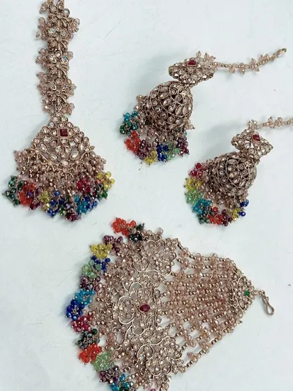 Brighten up your pre-wedding functions with my special Haldi and Mehendi collection. This set features a maang tikka, hath phool, and earrings with vibrant, multi-color beads that will perfectly complement your festive outfits.