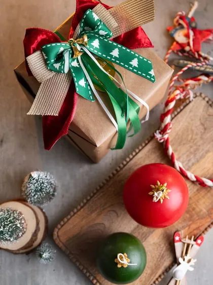 A festive flat-lay showing my large ornament candles and a beautifully wrapped gift. The colors of Christmas are everywhere!