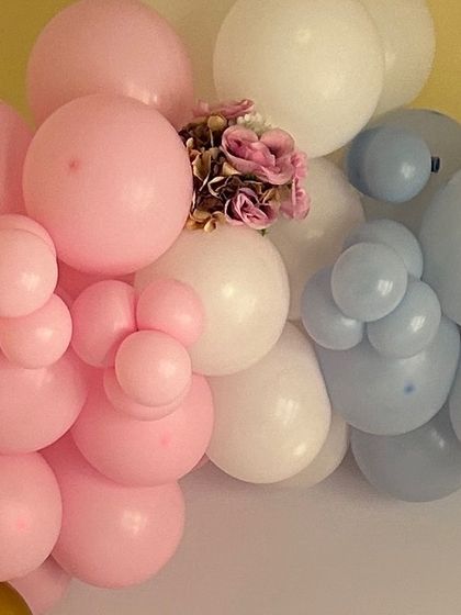 A close-up of a pastel balloon garland in pink, blue, and white. This soft and gentle color combination is perfect for baby showers and gender reveal parties.