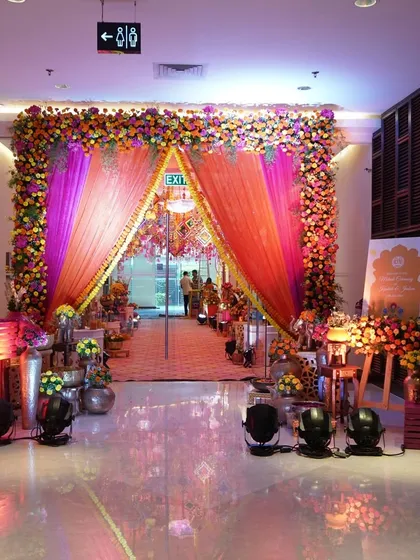 For this vibrant Mehendi, I designed a colorful entrance with an arch of bright orange and pink flowers, setting a joyful and festive tone.
