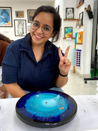 A participant with her finished galaxy resin clock. The beautiful blue swirls create a mesmerizing cosmic effect.