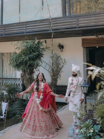 A happy, candid shot of the bride leading the groom at their destination wedding venue.