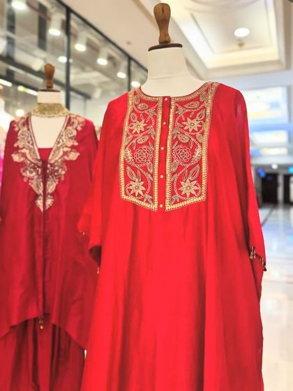A closer look at the red and orange kaftans, highlighting the intricate embroidery on the neckline.
