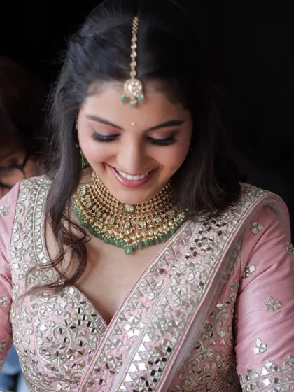 A close-up of this bride's happy smile during her engagement. The soft pink makeup and mirror-work lehenga create a beautiful, fresh look.