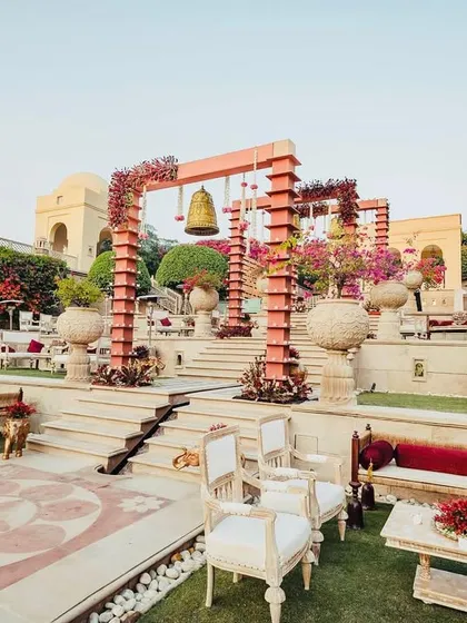 A royal affair set against a stunning heritage backdrop. This poolside phera setup combined grand temple bells, rich florals, and elegant lounge seating, creating a truly magical atmosphere for the vows.