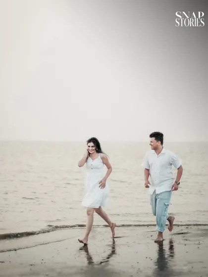 A fun, action shot of the couple running along the shoreline, adding a sense of energy and playfulness to their pre-wedding photography collection.