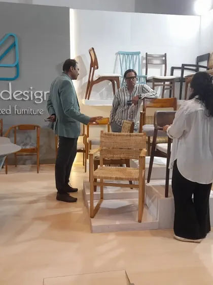 Visitors exploring the "chair wall" at my booth, where I displayed a wide range of seating designs, from modern to classic.
