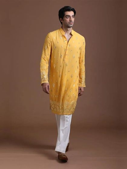 A full view of the yellow kurta with detailed embroidery on the sleeves. The complete look is both traditional and effortlessly stylish.