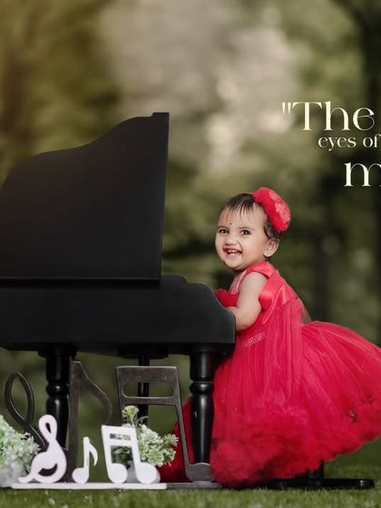 The world through the eyes of a child is pure magic. A happy girl in a red dress plays the piano in the park.